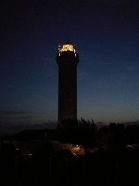 Silhouette lighthouse against clear sky at night