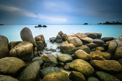 Rocks on sea shore against sky