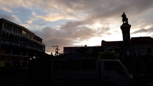 Silhouette buildings against sky at sunset