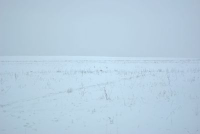 Scenic view of snow covered land against clear sky