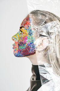 Portrait of a woman with multi colored face paint
