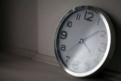 Close-up of clock against wall at home