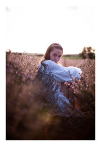Portrait of woman sitting in a lavender field during sunset 