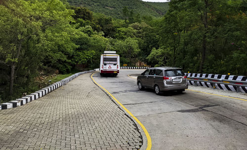 Cars on road against trees in city