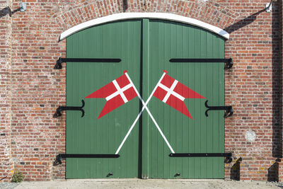 Denmark, romo, danish flags painted on wooden gate of fire station
