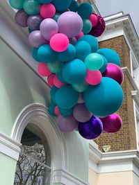 Low angle view of multi colored balloons against building