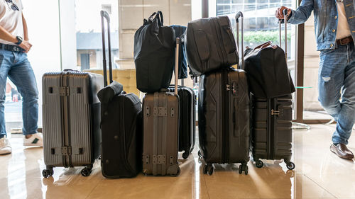 Low section of men standing with luggages at airport