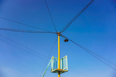 Low angle view of electricity pylon against clear sky