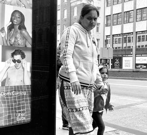 Full length of mother and daughter standing in city