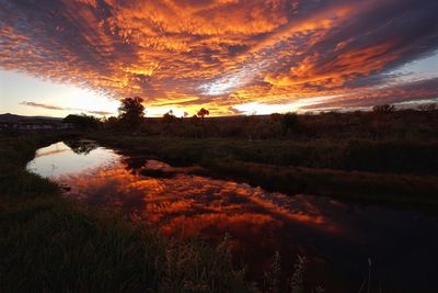 Scenic view of river against sky at sunset