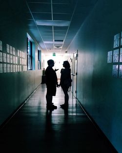 Rear view of silhouette people walking in corridor