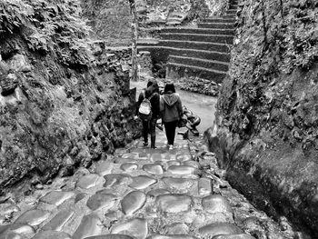 Rear view of people walking on steps