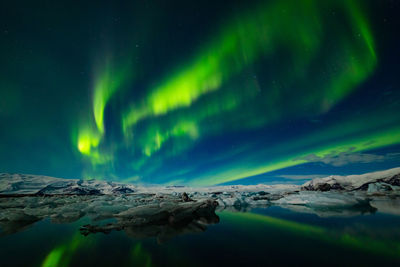 Scenic view of snowcapped mountains against sky at night