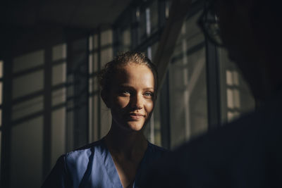 Sunlight falling on face of young female nurse in hospital