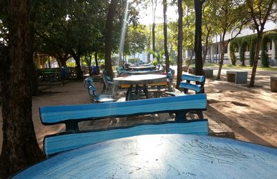 Chairs and table by swimming pool against trees