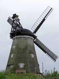 Low angle view of traditional windmill against sky