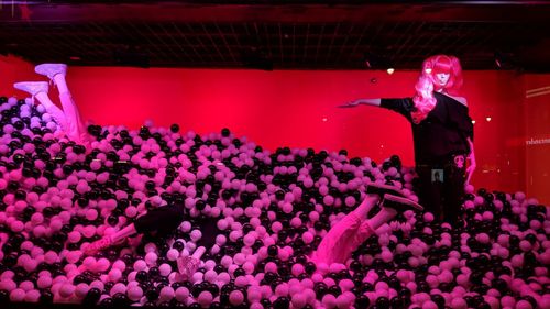 Rear view of people standing by pink flowers