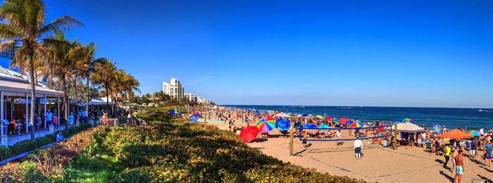 Crowded sands of deerfield beach near the pier with unrecognizable faces in deerfield, florida