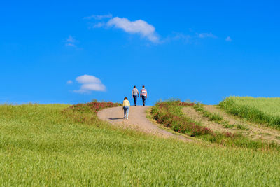 People walking against blue sky