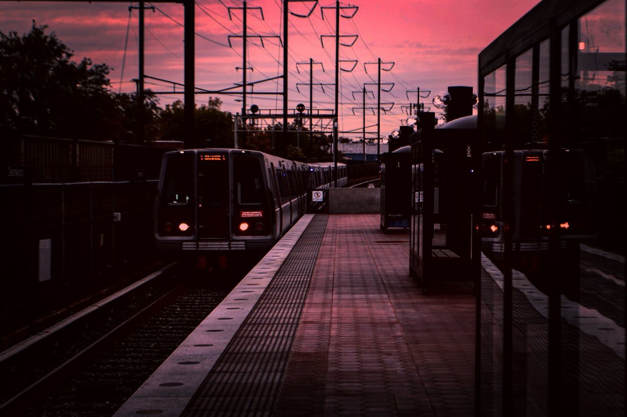 railroad track, transportation, sunset, rail transportation, the way forward, railroad station, railroad station platform, public transportation, sky, built structure, architecture, building exterior, diminishing perspective, mode of transport, street light, illuminated, vanishing point, dusk, travel, orange color