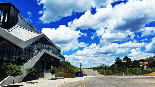 Road by houses against blue sky