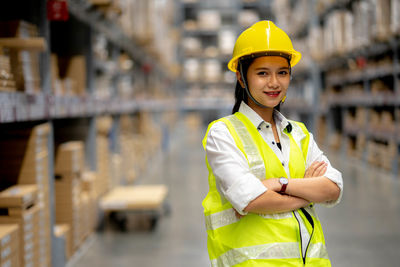 Portrait of smiling woman standing at construction site