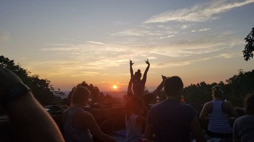 People enjoying at music concert against sky during sunset