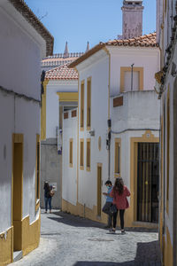 Rear view of people walking on building in city