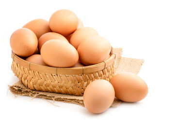 Close-up of eggs in nest against white background