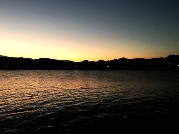 Scenic view of silhouette mountains against clear sky at sunset