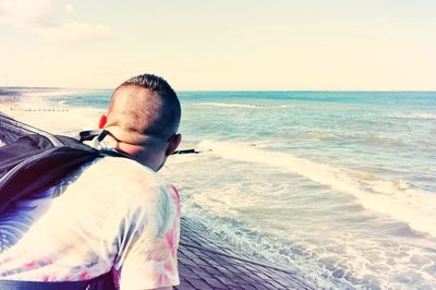 Man standing at beach against sky