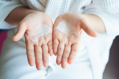 High angle view of moisturizer on palm of hands 