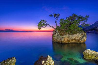 Scenic view of brela stone against sky and sea at sunset