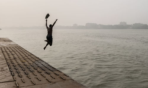 Woman jumping in swimming pool