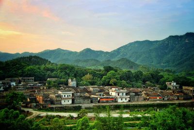 Houses in village against sky during sunset