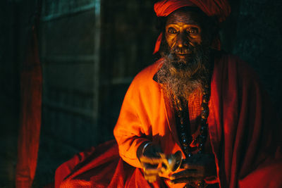 Midsection of religious man singing chants at night