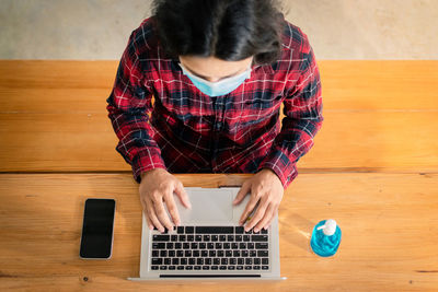 High angle view of girl using laptop on table