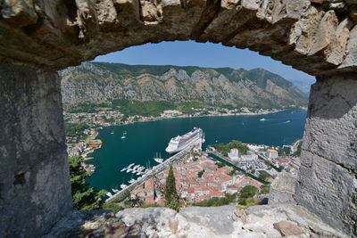 High angle view of mountain by sea seen through window