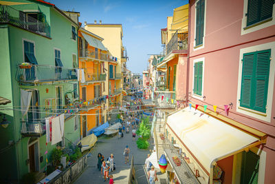 People on street amidst buildings in city against sky