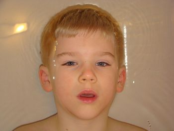 Close-up portrait of boy in bathtub