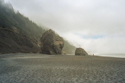 Scenic view of beach against cloudy sky