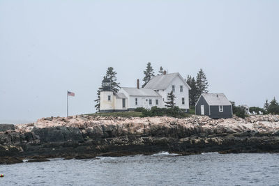 House by sea against clear sky