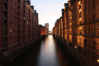 Canal along buildings at sunset