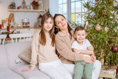 Family spends time together during christmas holidays in decorated house.