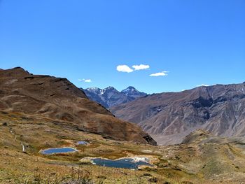 Scenic view of mountains against blue sky