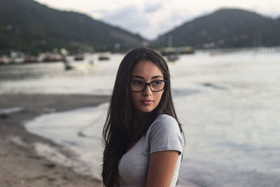 Portrait of beautiful young woman standing on beach