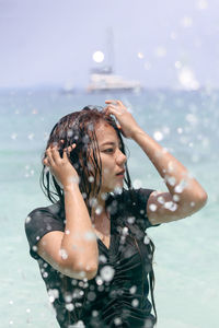 Young woman with wet hair in water