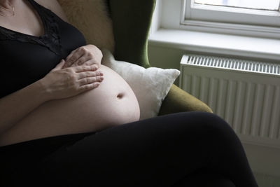 Midsection of woman sitting at home