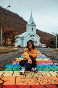 Young woman sitting on temple against building