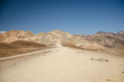 Scenic view of arid landscape against clear blue sky